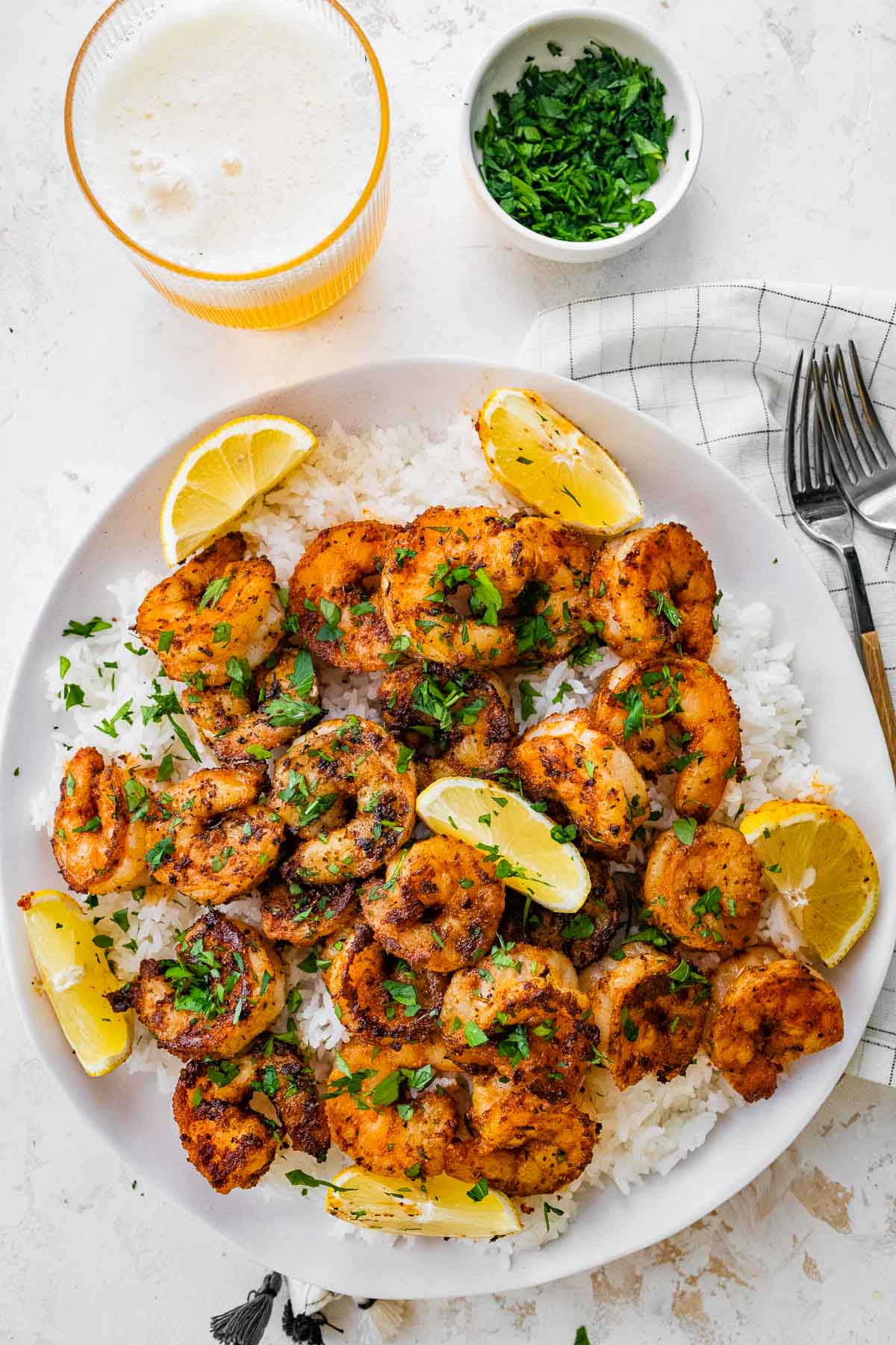 Cajun Shrimp cooked and garnished shrimp on plate with lemon wedges and rice