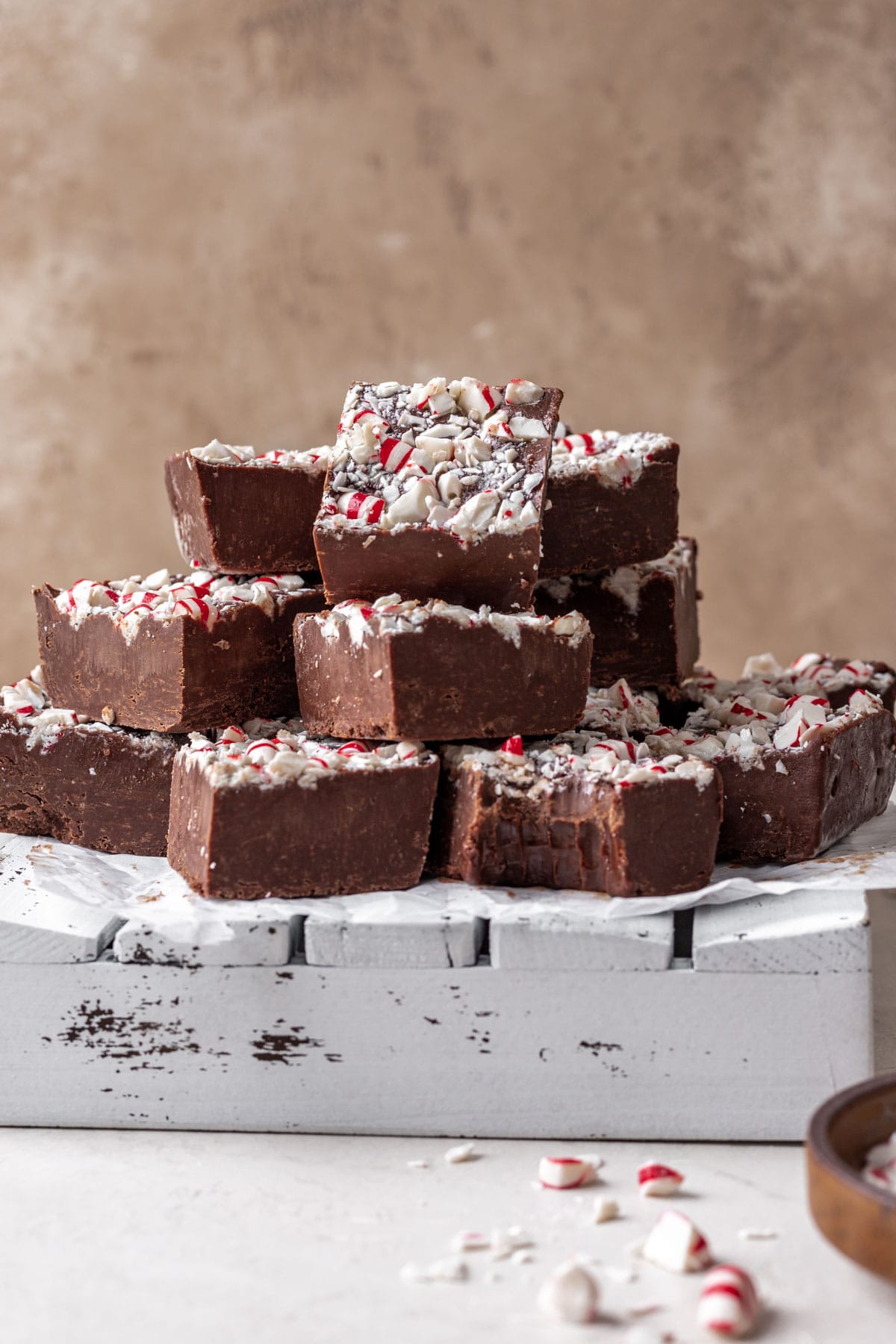 Chocolate Peppermint Fudge finished fudge cut in squares and stacked with bite taken out of one bottom square