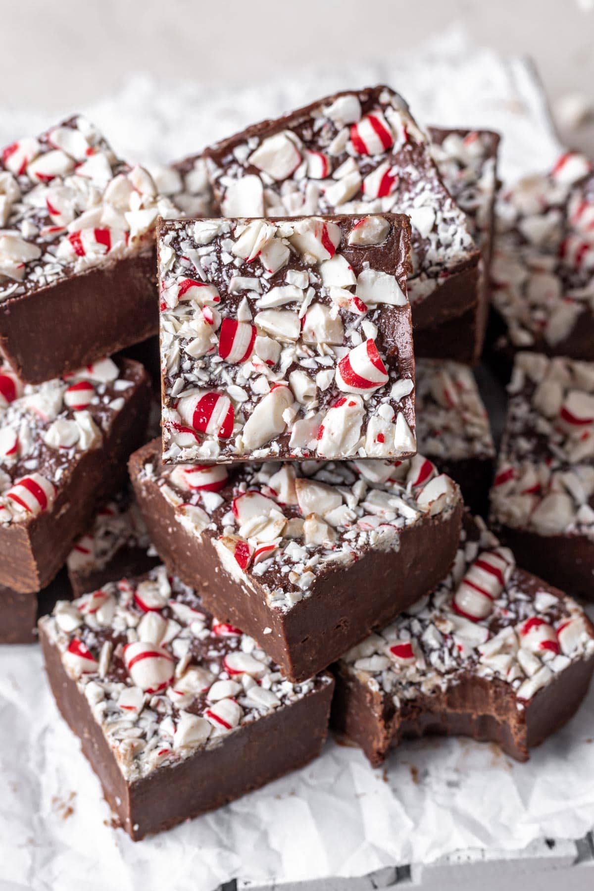 Chocolate Peppermint Fudge finished fudge cut in squares and stacked with bite taken out of one bottom square