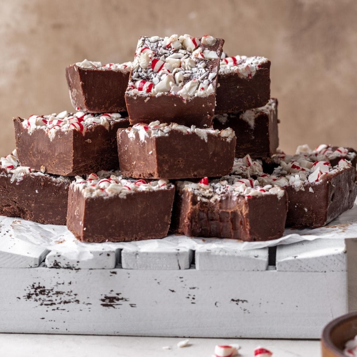 Chocolate Peppermint Fudge finished fudge cut in squares and stacked with bite taken out of one bottom square