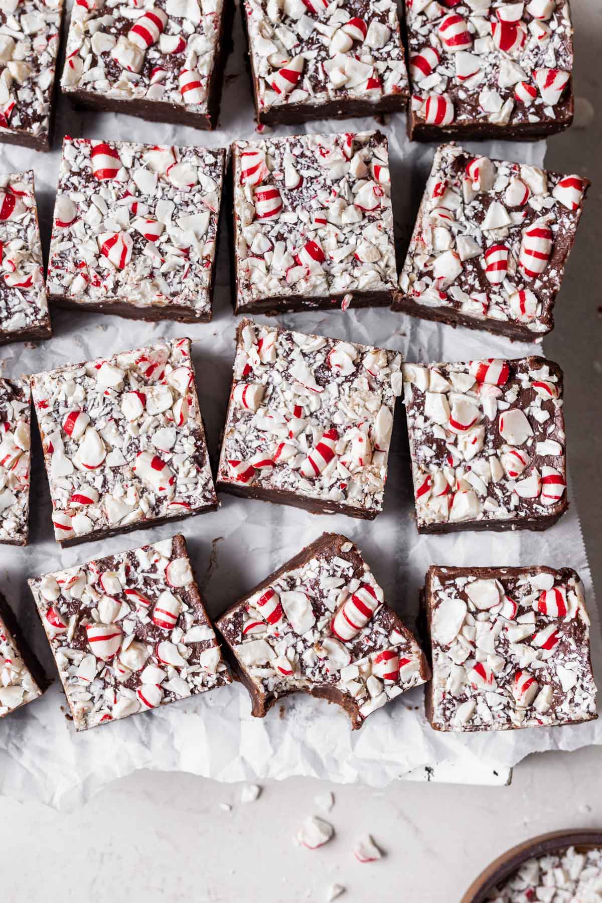 Chocolate Peppermint Fudge finished fudge cut into squares in single layer with bite taking out of one square