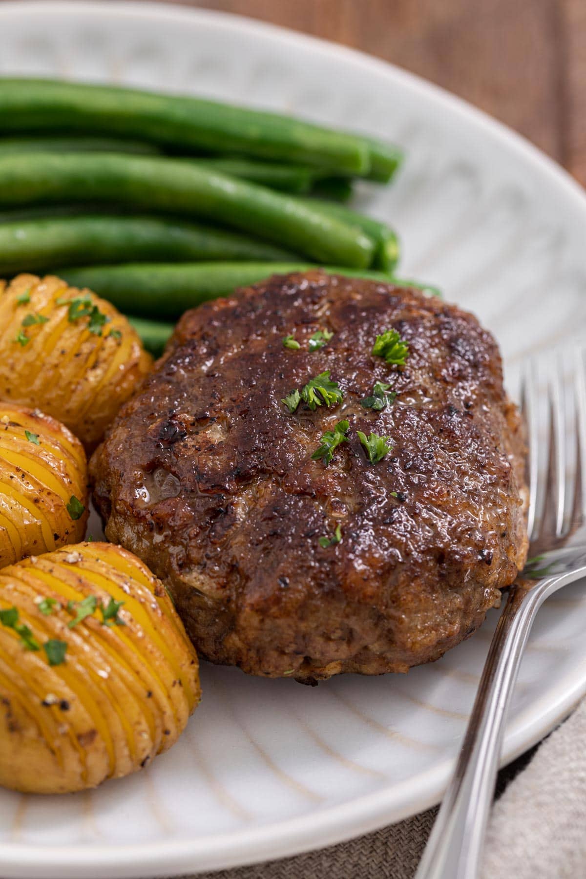 Chopped Steak cooked steak on plate with potatoes and green beans