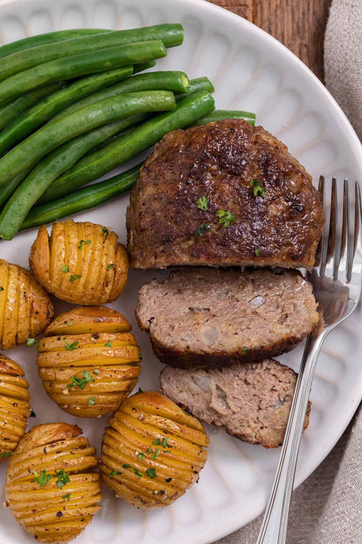 Chopped Steak cooked steak sliced on plate with potatoes and green beans