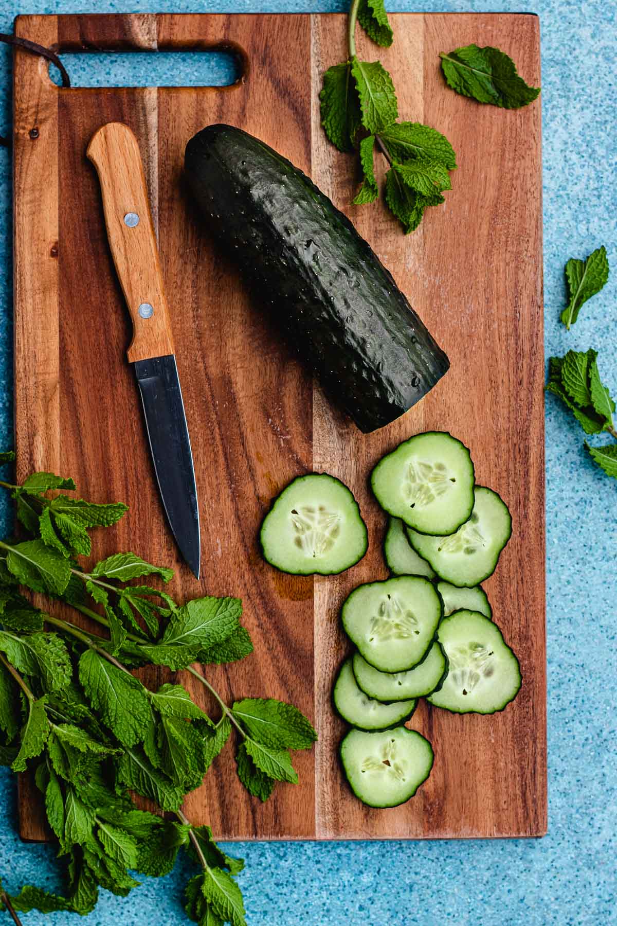 Cucumber Water ingredients on cutting board with some slices cut