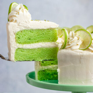 Key Lime Cake lifting slice on cake server away from finished cake