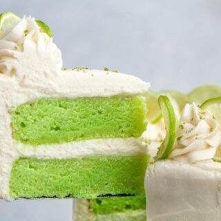 removing a slice of green cake with a layer of frosting