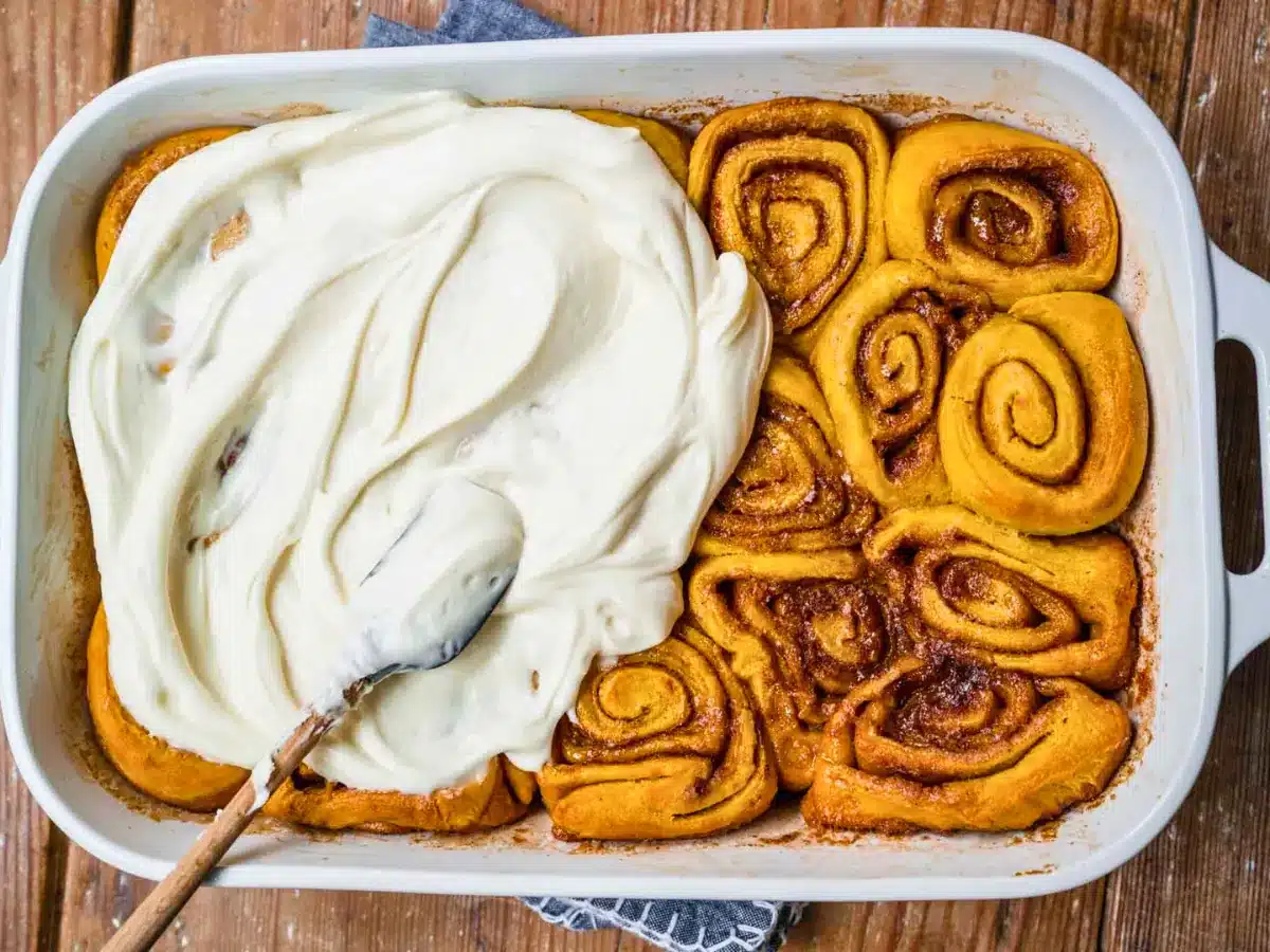 Cinnamon rolls being frosted