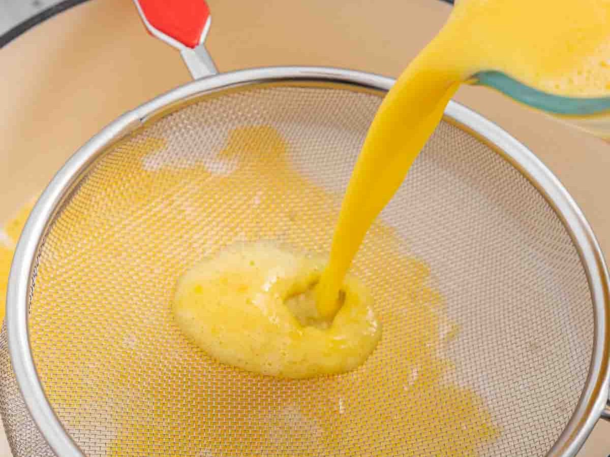 Straining milk and egg mixture.