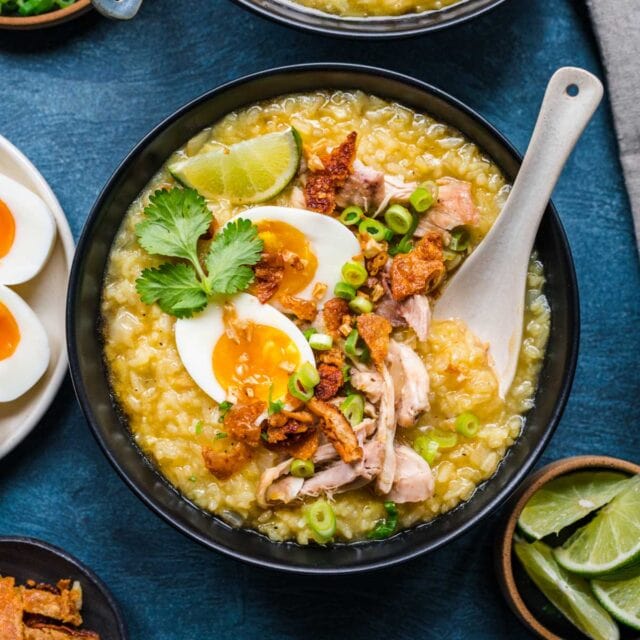 Arroz Caldo finished in bowl with toppings with spoon