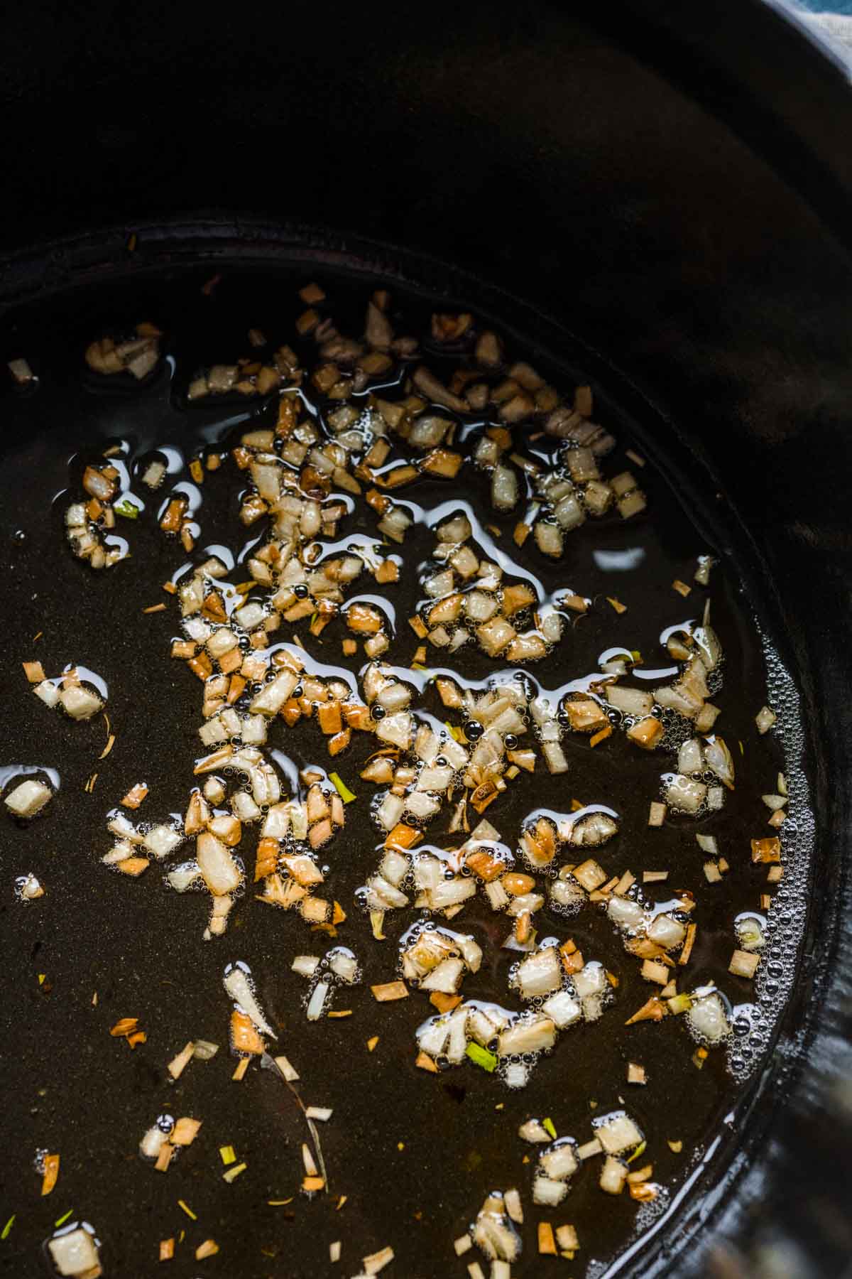 Arroz Caldo garlic pieces frying in pan