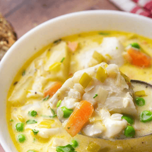 Close up of soup in a bowl with a spoon serving