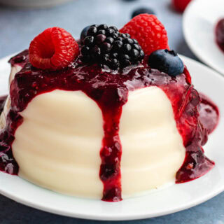 Vanilla custard topped with berries and sauce.