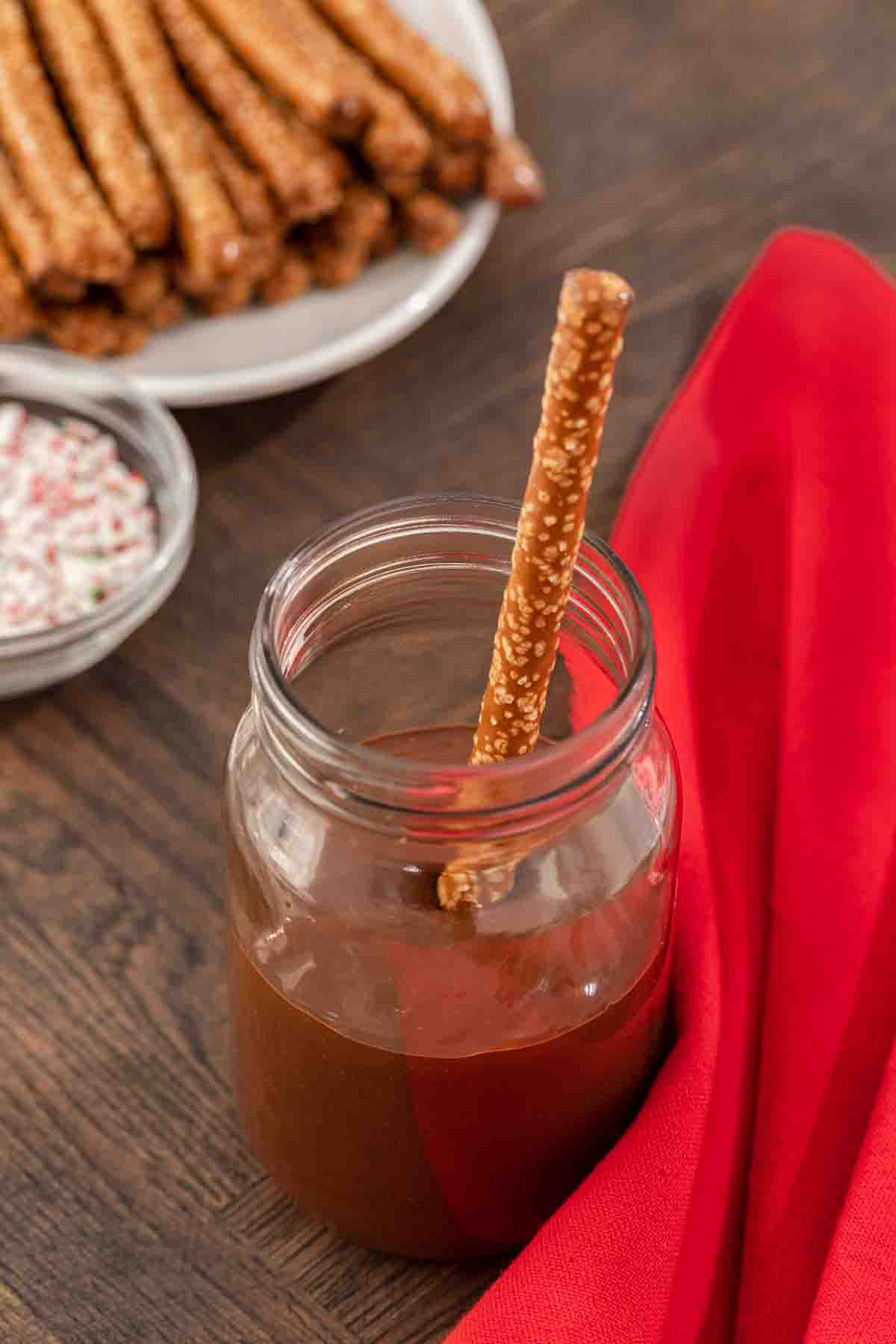 Peppermint Bark Pretzels chocolate melted in jar with pretzel rod
