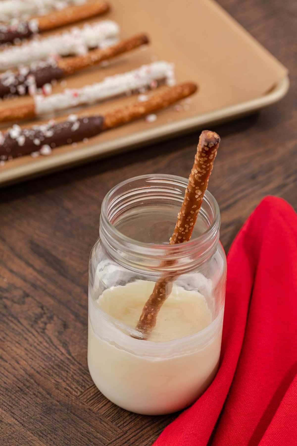 Peppermint Bark Pretzels white chocolate melted in jar with pretzel rod