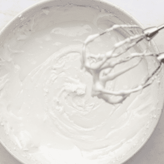 icing in a bowl with mixers covered in icing