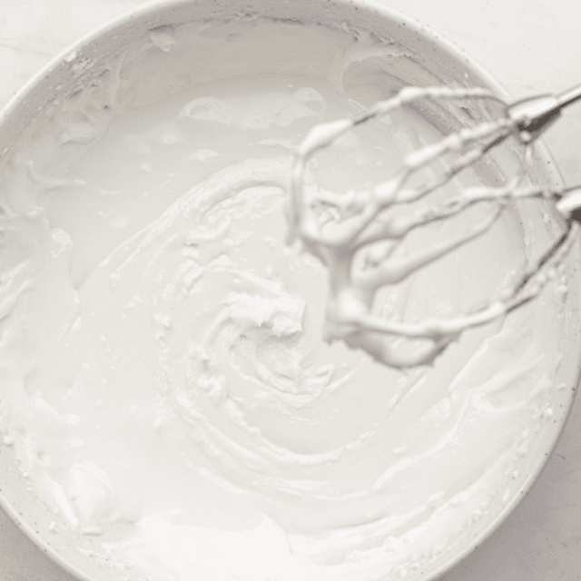 icing in a bowl with mixers covered in icing