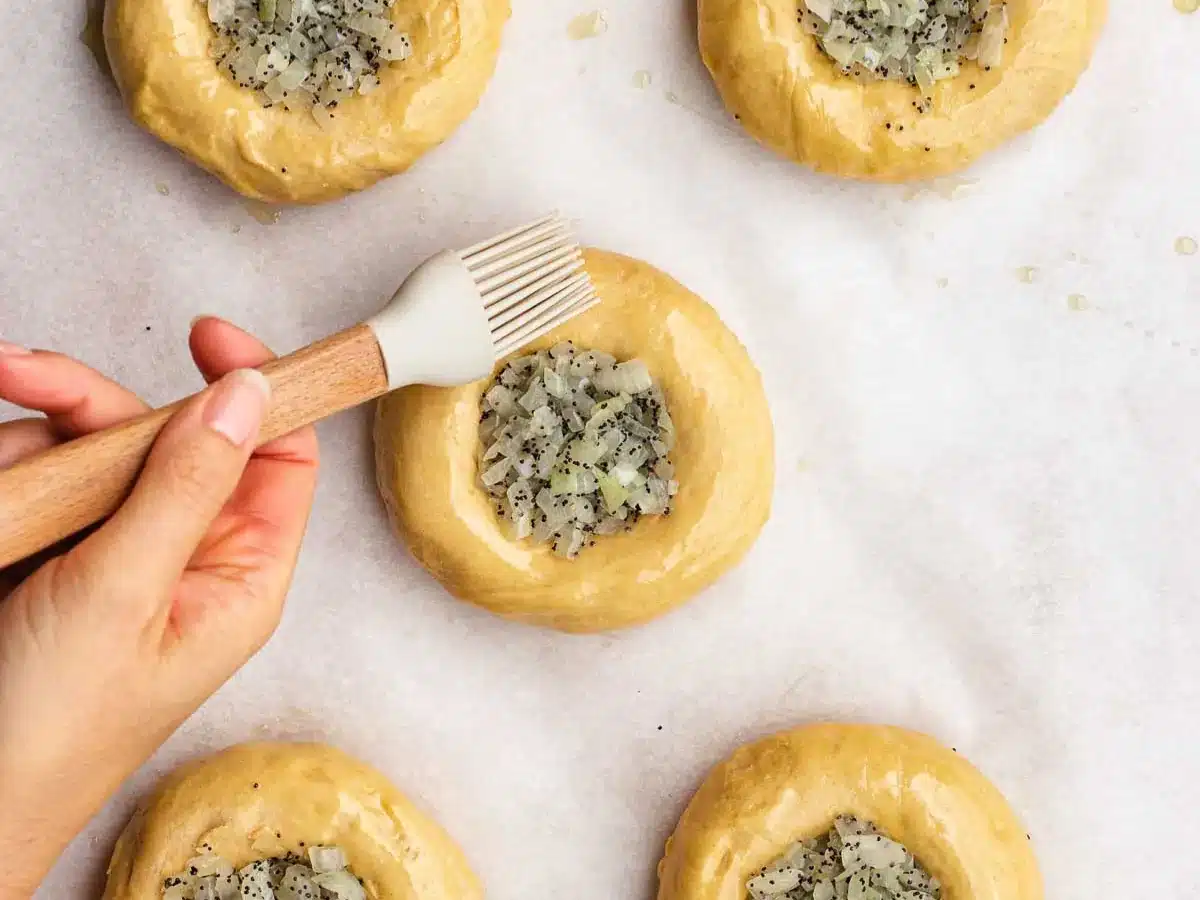 Rolls with onion center being brushed with oil.