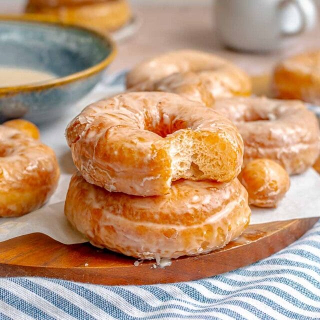 two donuts stacked with top donut missing bite, 4x3