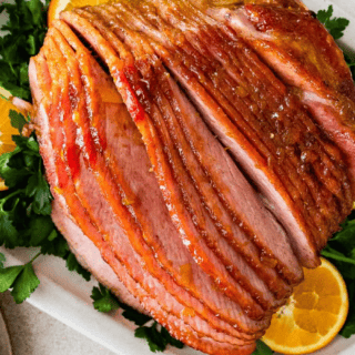 Baked spiral ham cooked on serving platter with garnishes