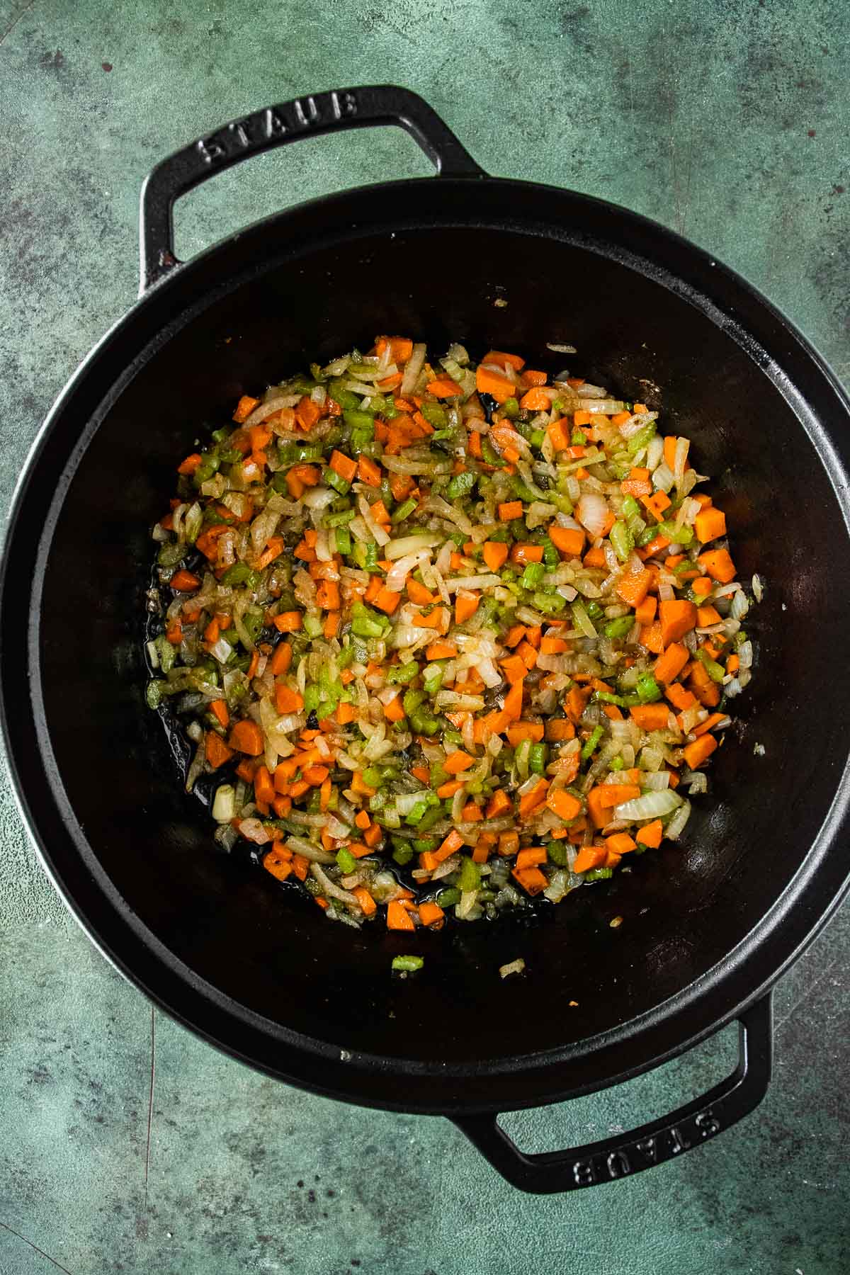 Guinness Braised Short Ribs sauteed onions, carrots, and celery in cooking pot