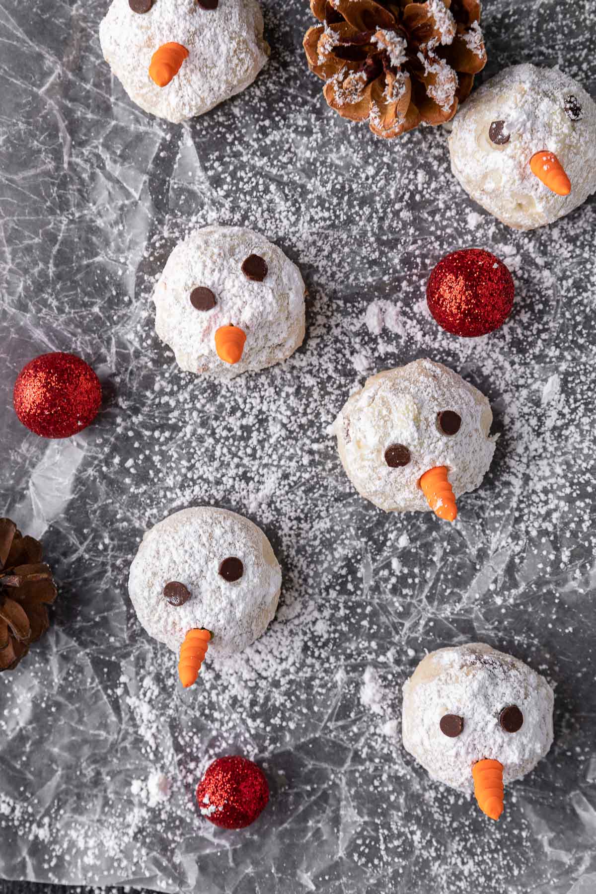 Snowman Snowball Cookies decorated and spread out on baking sheet