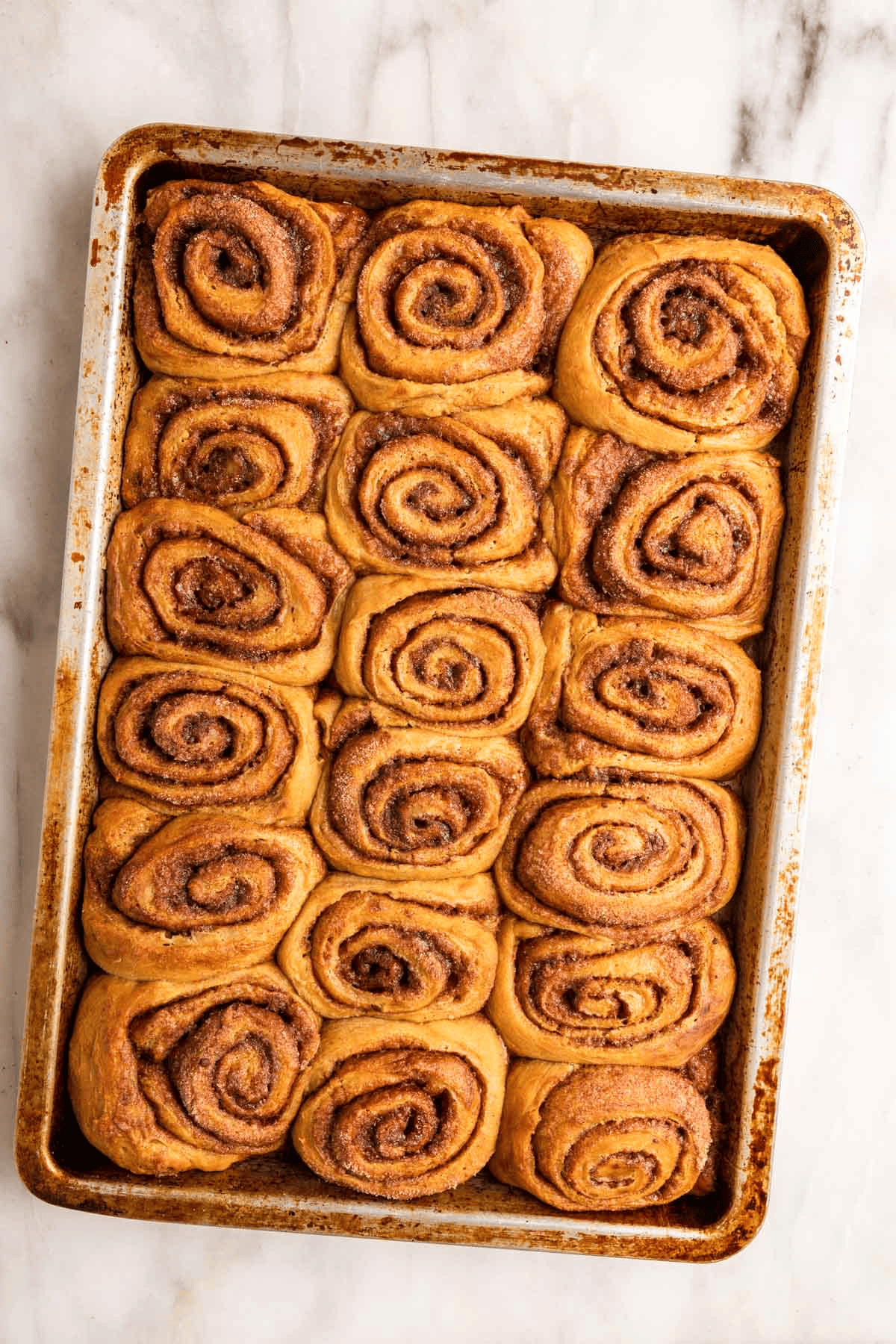 18 baked pastry rolls in a baking sheet
