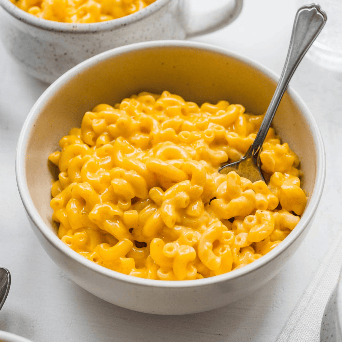 Mac and cheese in a white bowl with a fork