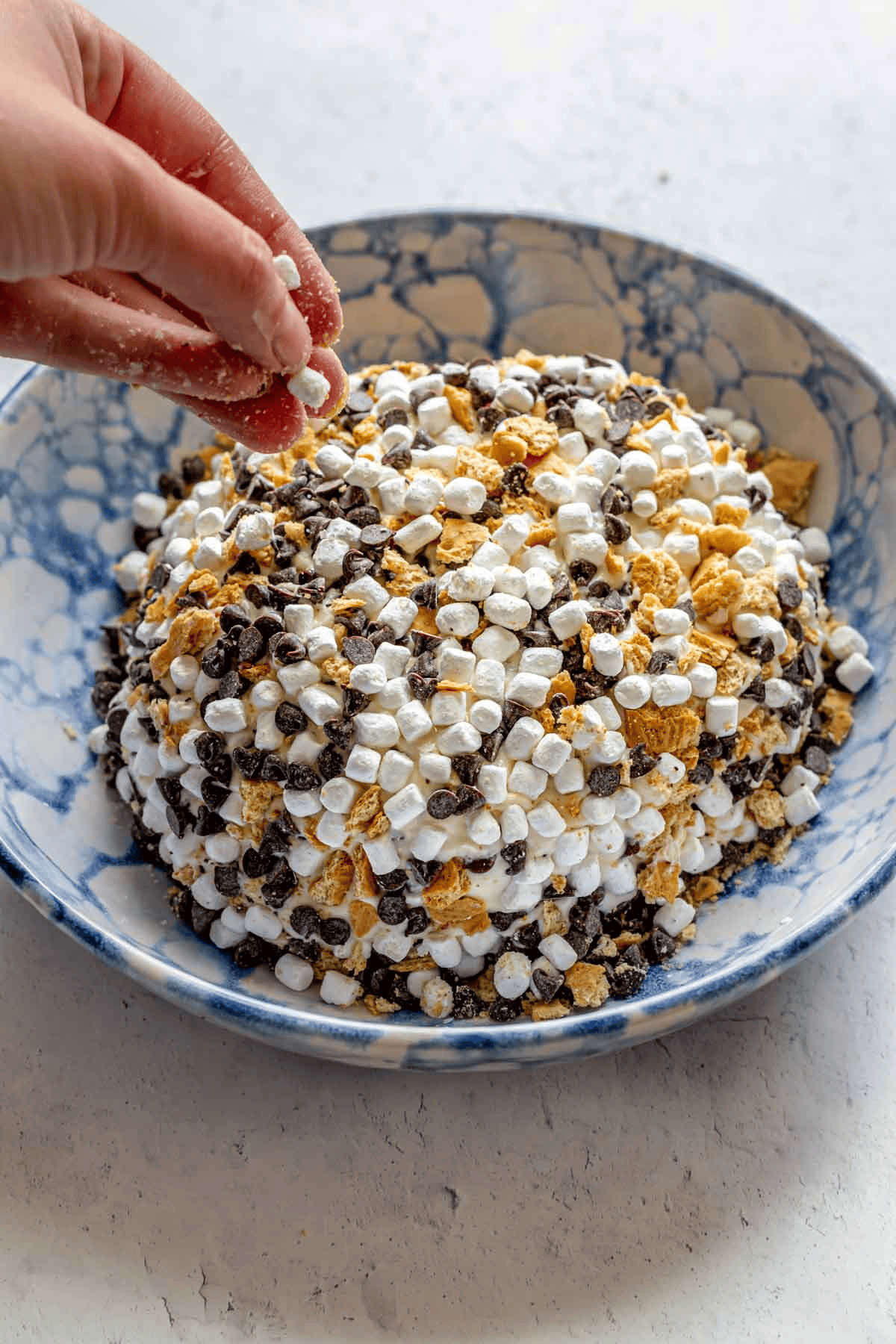 cream cheese ball coated in marshmallows, crackers, and chocolate chips