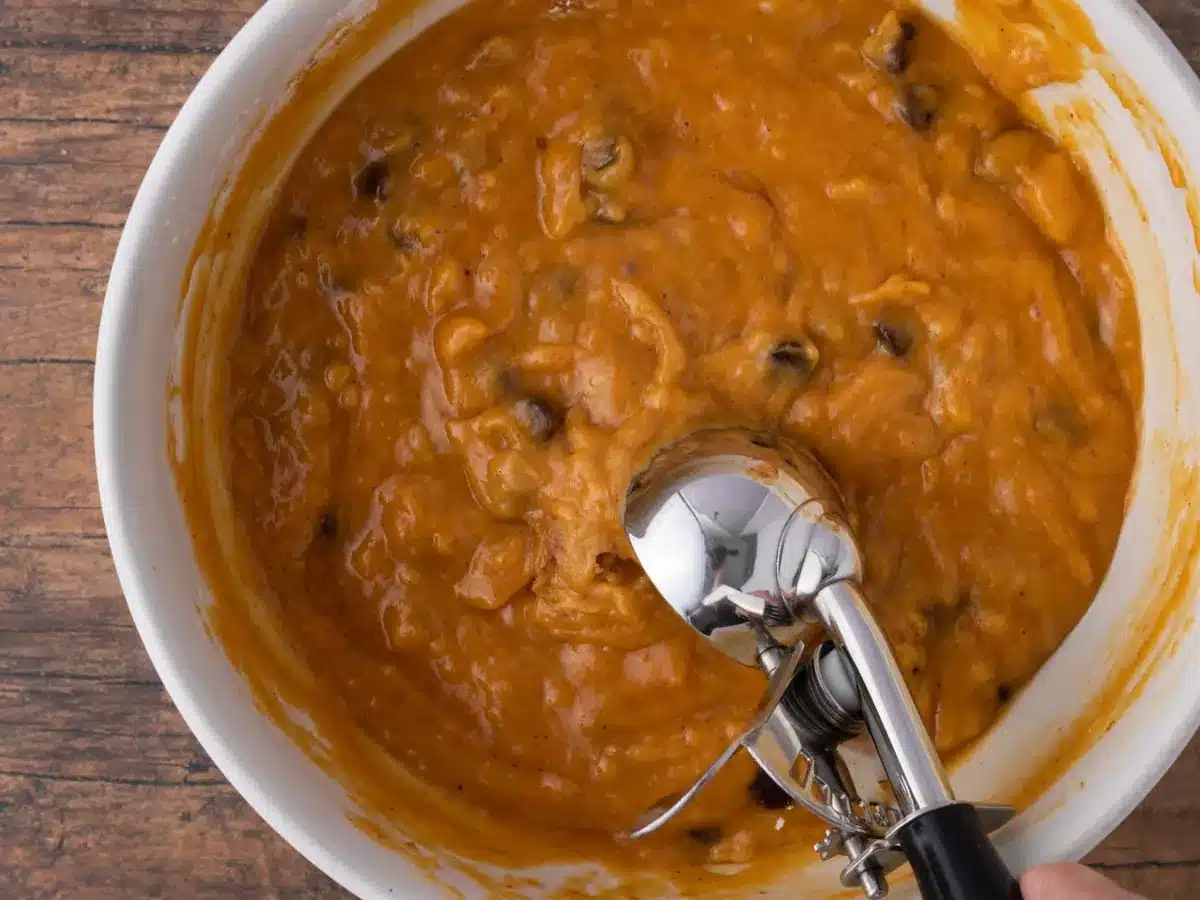 Raw dough with scoop in bowl. 