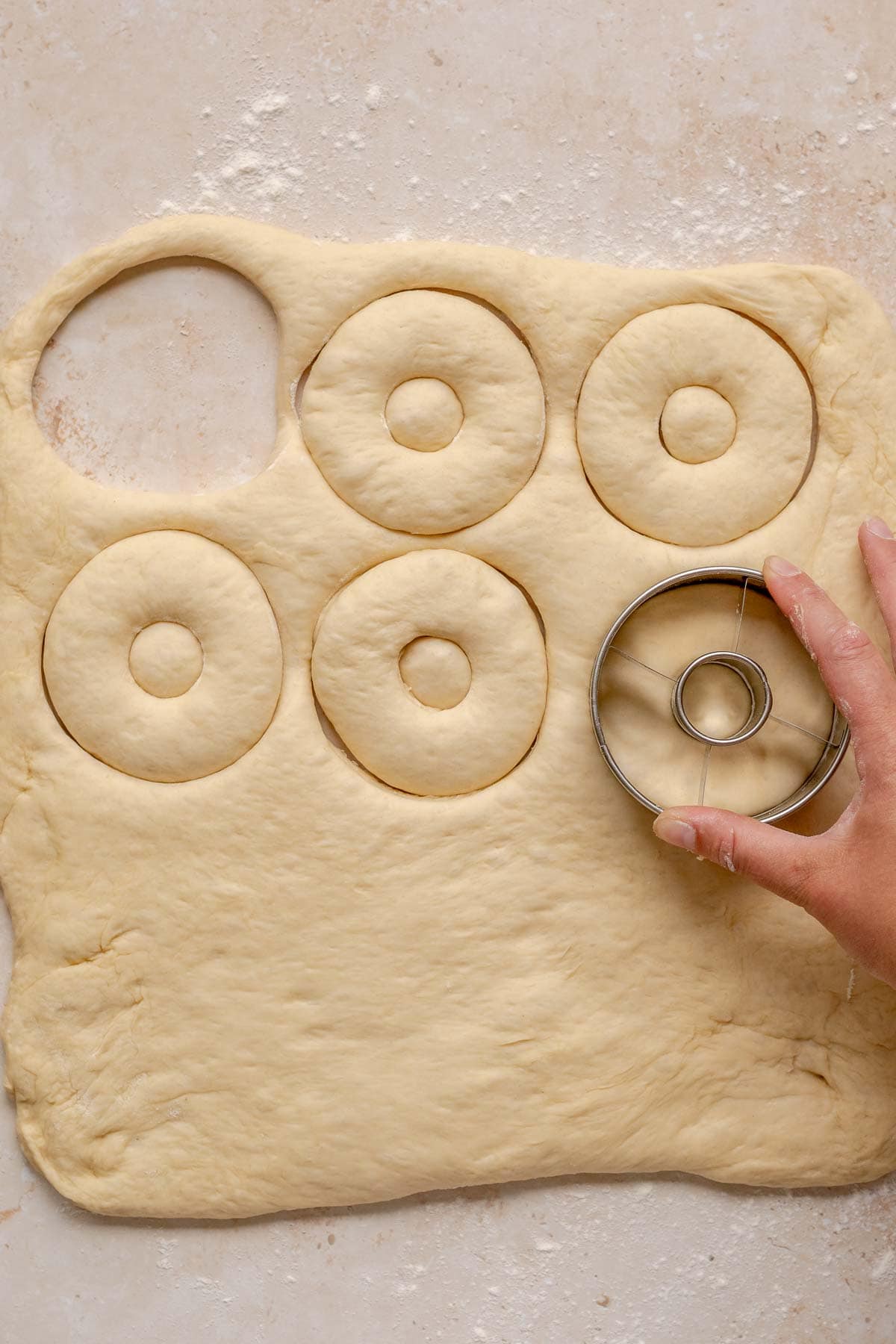 Yeast Donuts cutting sheet of dough with cutter