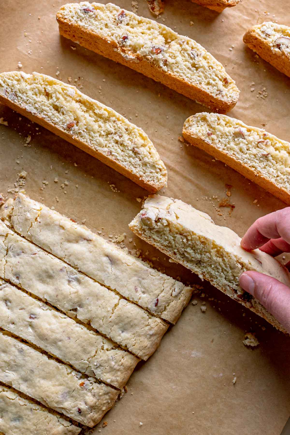 Almond Biscotti Cookies separating cookie slices from log and flipping them