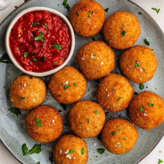 Arancini with spicy marinara on plate.