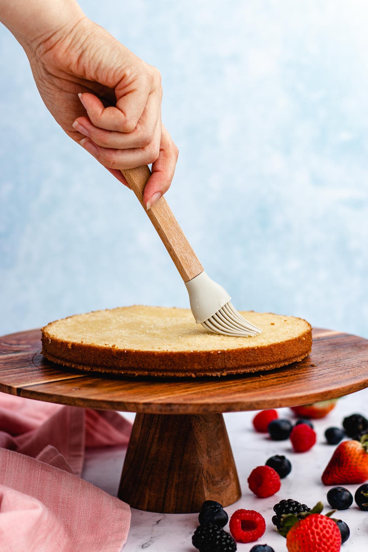 putting simple syrup on cake layer 