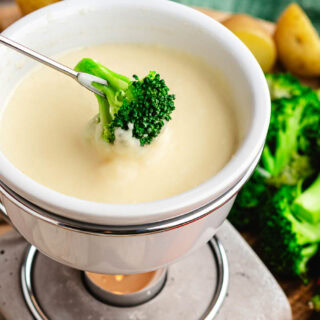Broccoli floret dipped in fondue.