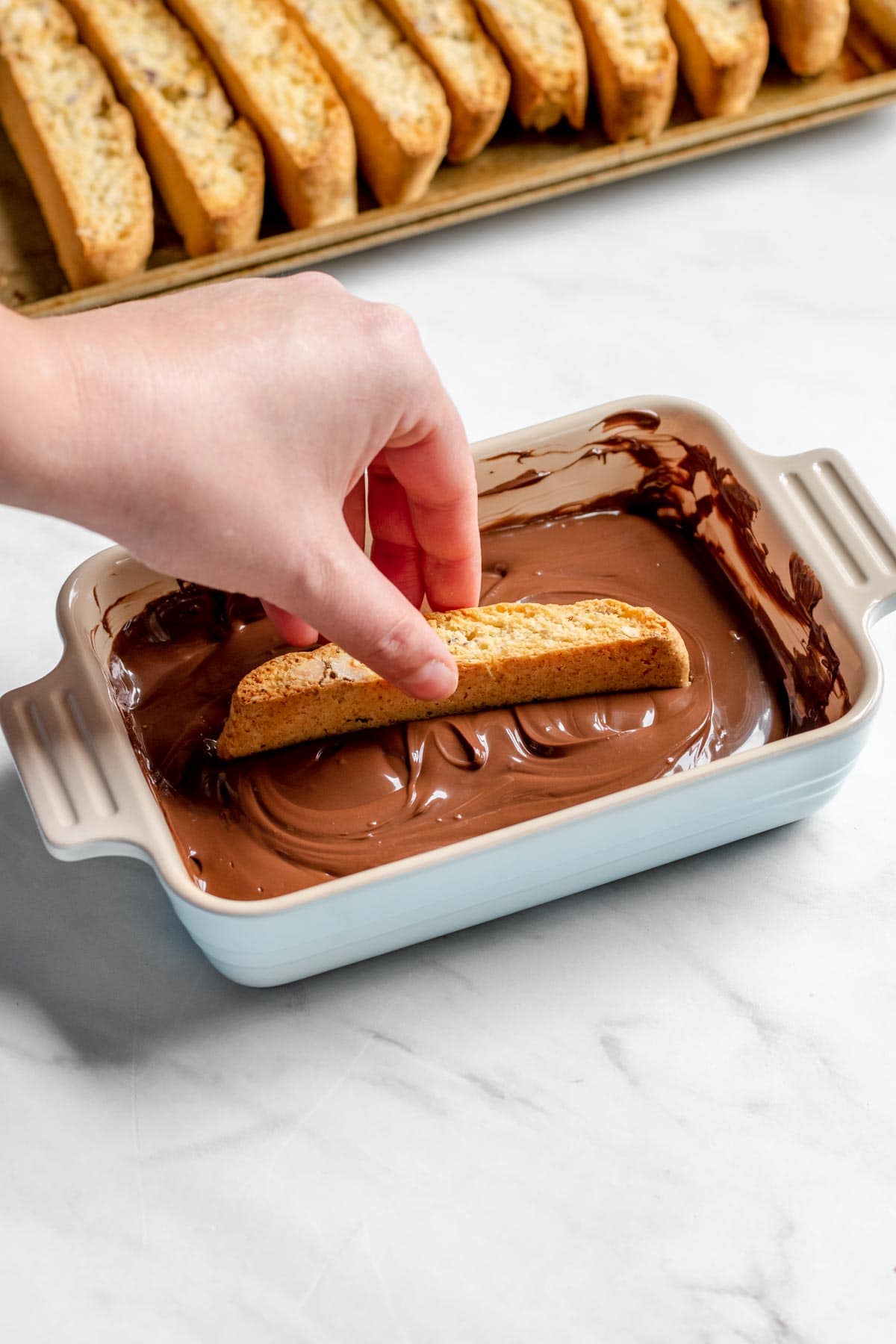 Chocolate Hazelnut Biscotti dipping cookie in melted chocolate