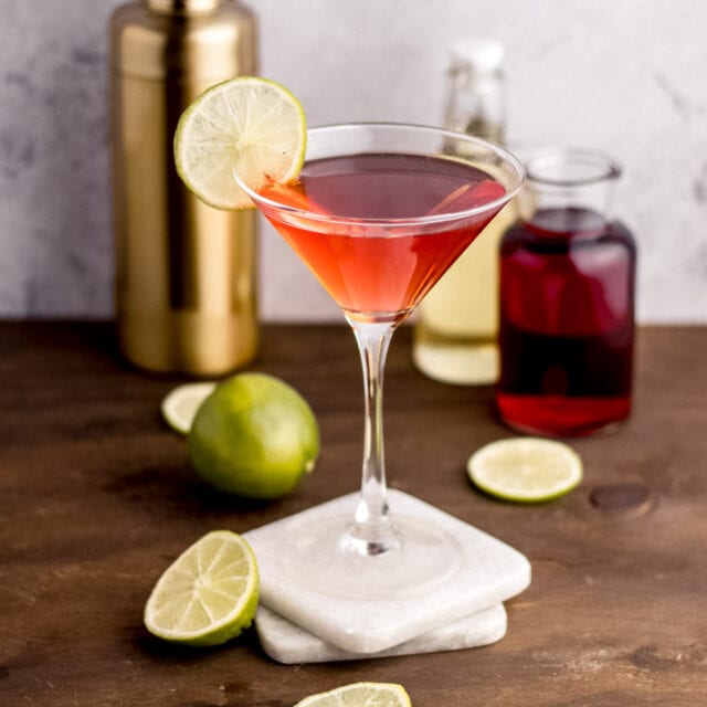 Cosmopolitan Cocktail in glass with ingredients in background, 1x1