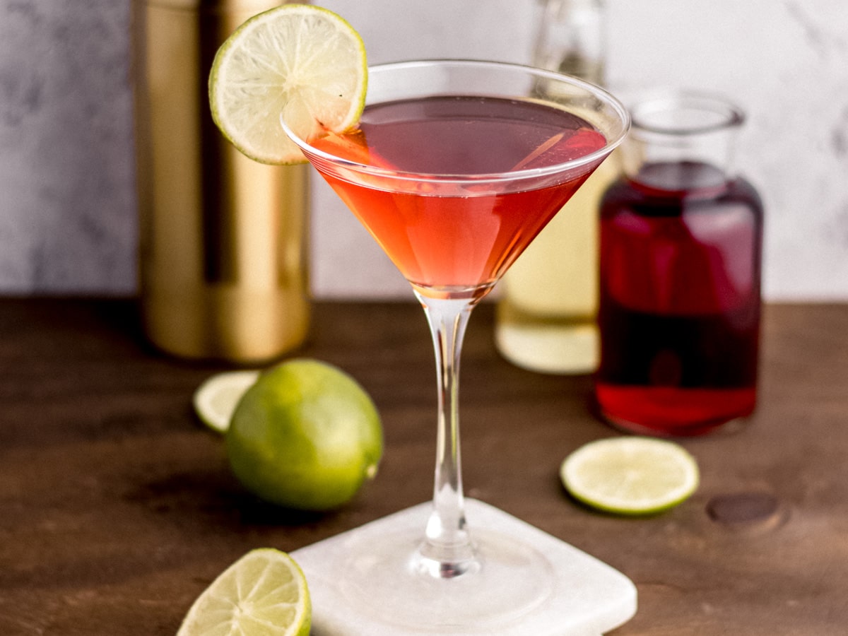 Cosmopolitan Cocktail in glass with ingredients in background, 4x3