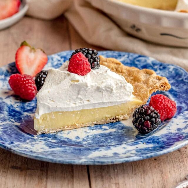 Cream Pie slice on plate with berries on top and on plate, 1x1
