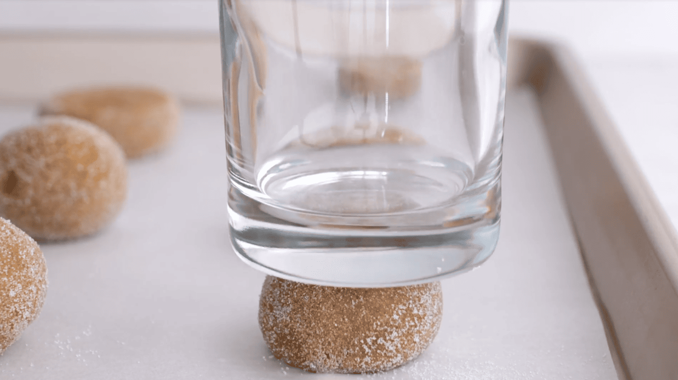 cup flattening a round dough ball