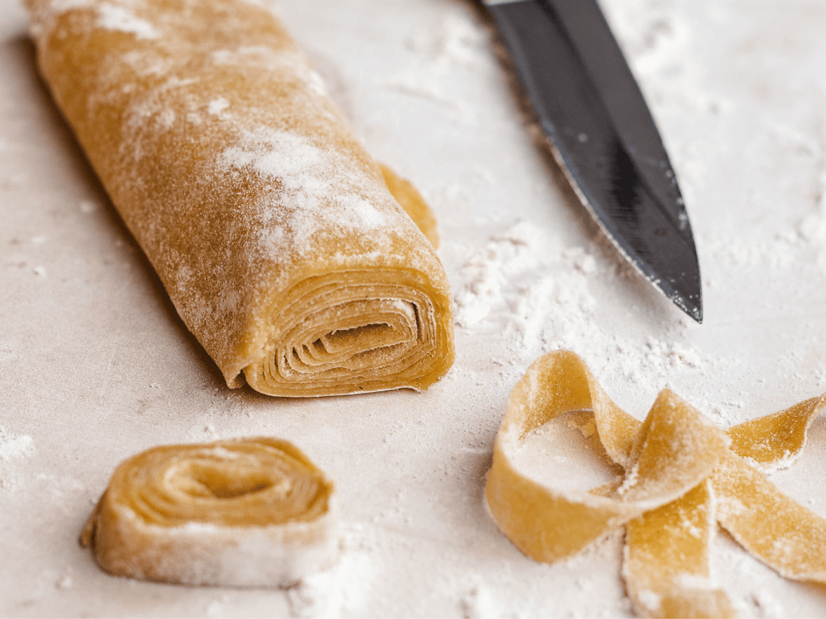 Dough rolled up, then sliced into noodle strands.