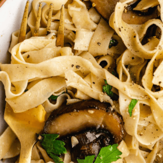 Pasta with mushrooms on dinner plate.