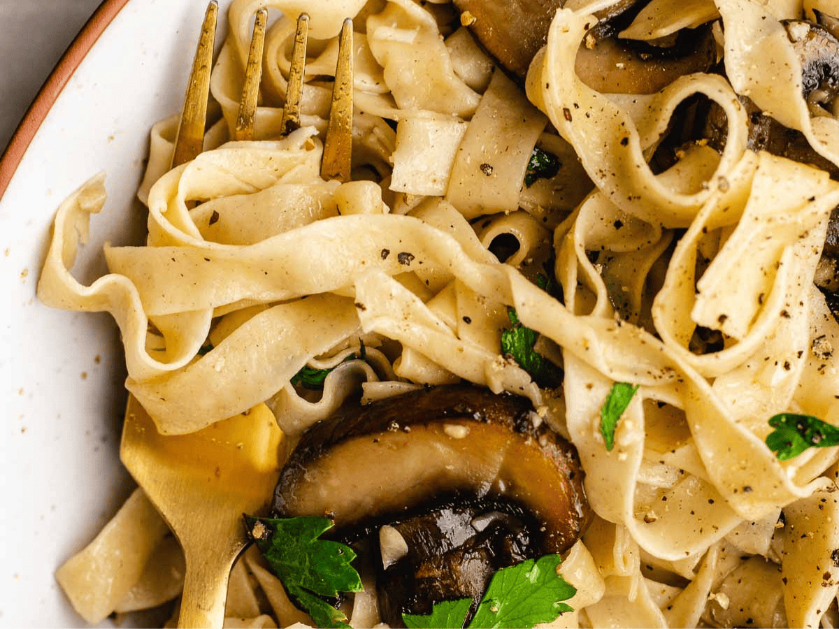 Pasta with mushrooms on dinner plate.