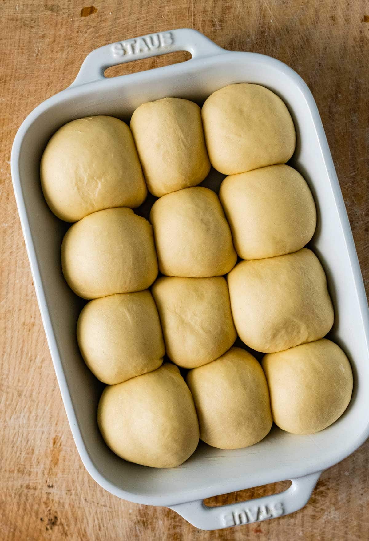 12 risen dough balls in baking pan