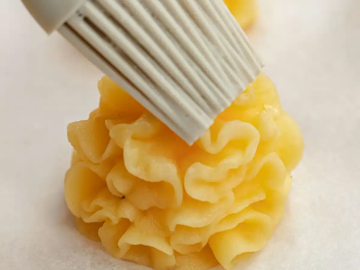 Egg wash being brushed over top.