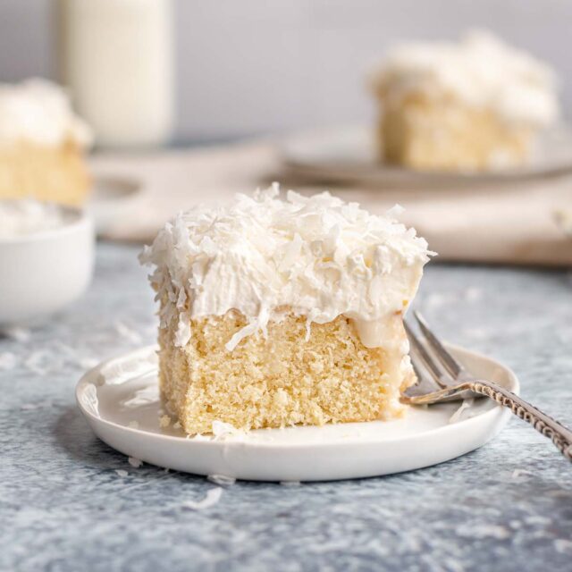 Coconut Poke Cake slice of cake on plate with fork, 1x1