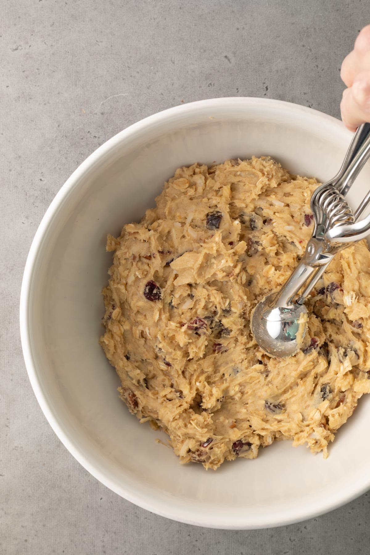 Breakfast Cookies scooping dough in bowl with cookie scoop