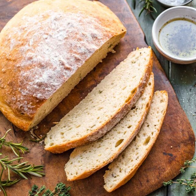 Crusty Garlic Herb Bread baked and sliced on cutting board, 1x1