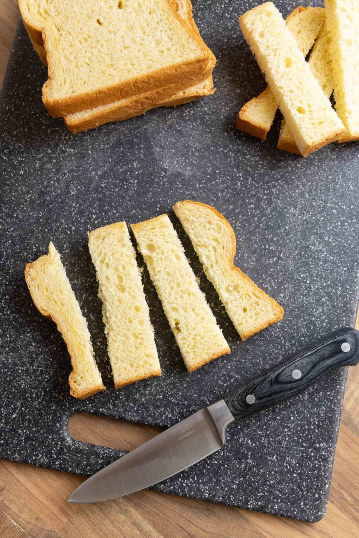French Toast Sticks sliced bread pieces and knife on cutting board
