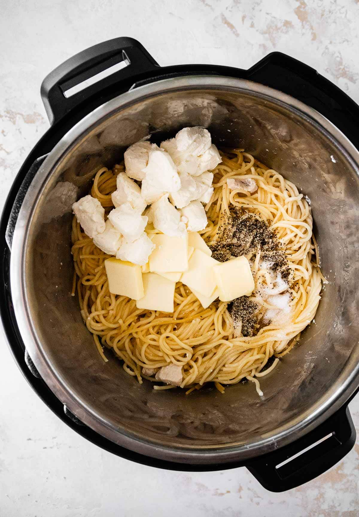 Instant Pot Chicken Alfredo cooked pasta and chicken in pot with sauce ingredients before mixing
