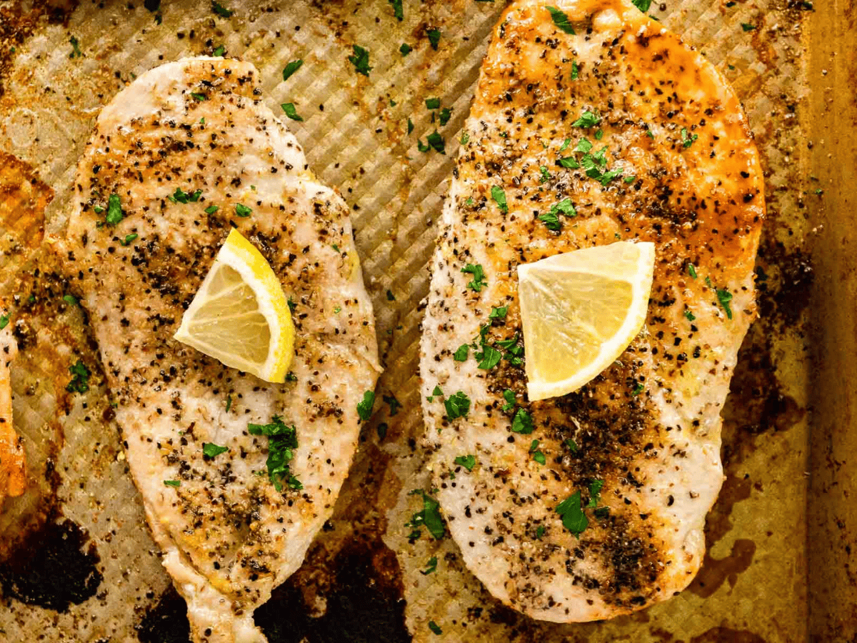 two chicken breasts cooked on a pan